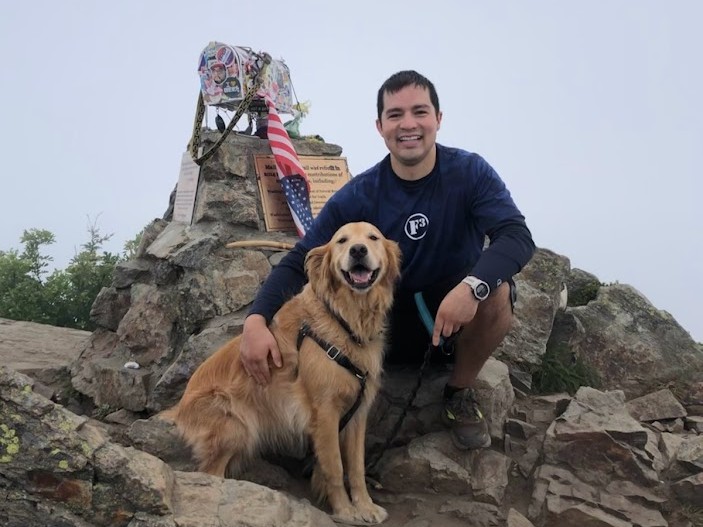 JD Gonzalez atop mailbox peak with dog